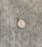 silver pendant dollop shape with yew tree in the center hanging on silver chain