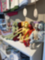 Collection of colourful handmade fabric bunnies sitting on a white shelf
