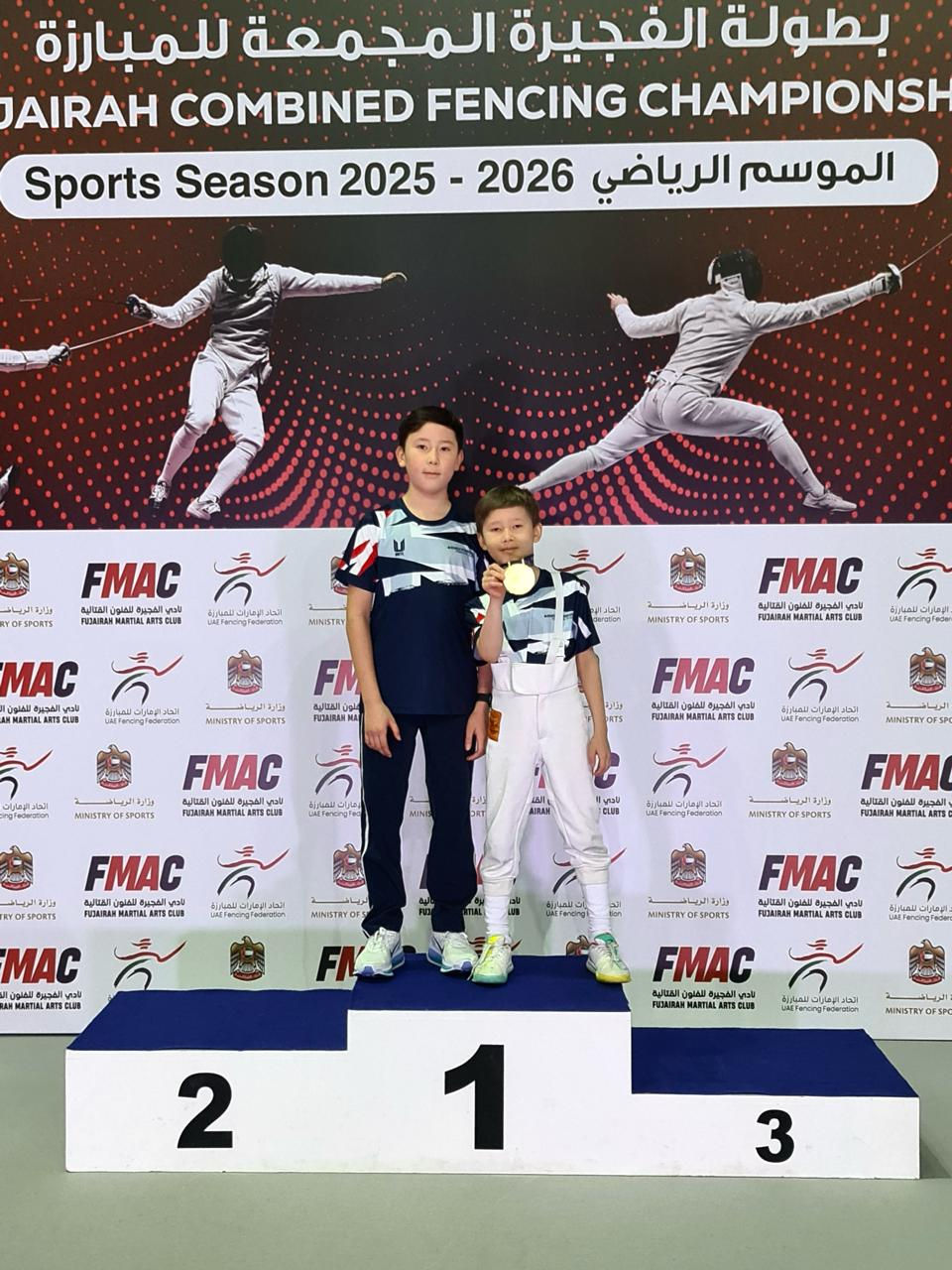 Knightsbridge Fencing Club fencers Danial and Altair celebrate their success at the Fujairah Fencing Championship 2026, with Danial winning the gold medal and Altair securing bronze after strong performances throughout the competition.