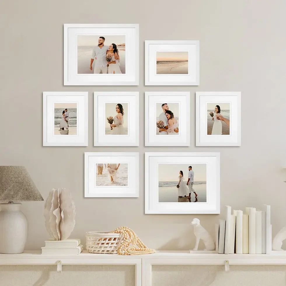 A collage of framed beach photos on a beige wall shows a couple in white outfits walking, laughing, and embracing, conveying romance.