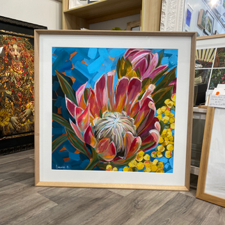 simple custom frame of a floral art print in an oak frame with a white mat board