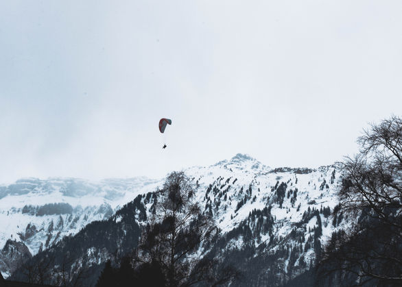 A parasailer takes flight in Interlaken on a windy day. Interlaken switzerland parasailing. Switzerland photography by Sam Mackey photographer.