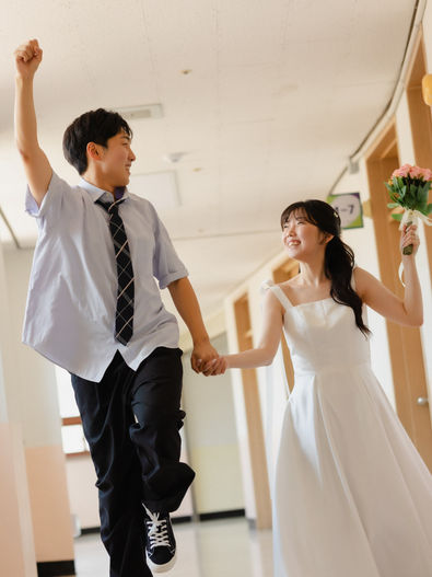 koil filmの前撮り写真 — 学校の廊下を手をつないで駆け下りる新郎新婦の躍動感あるスナップ