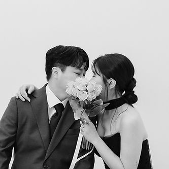 koil filmのフォト&ムービープラン撮影写真 — 白いバラの花束越しに寄り添う新郎新婦のモノクロスナップ