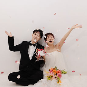 koil filmの前撮り写真 — 花びらとケーキを手に喜ぶ新郎新婦のスナップ(K様)