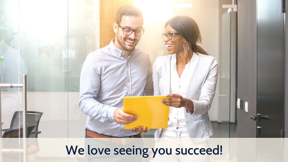Two business people smiling looking at a piece of paper. Bright and colorful photo captioned: "We love seeing you succeed!"