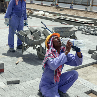Migrant worker drinking water at building site