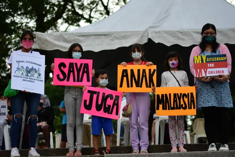 Malaysian mothers and children protesting, holding up placards with the words "Saya Juga Anak Malaysia (I am also a child of Malaysia).