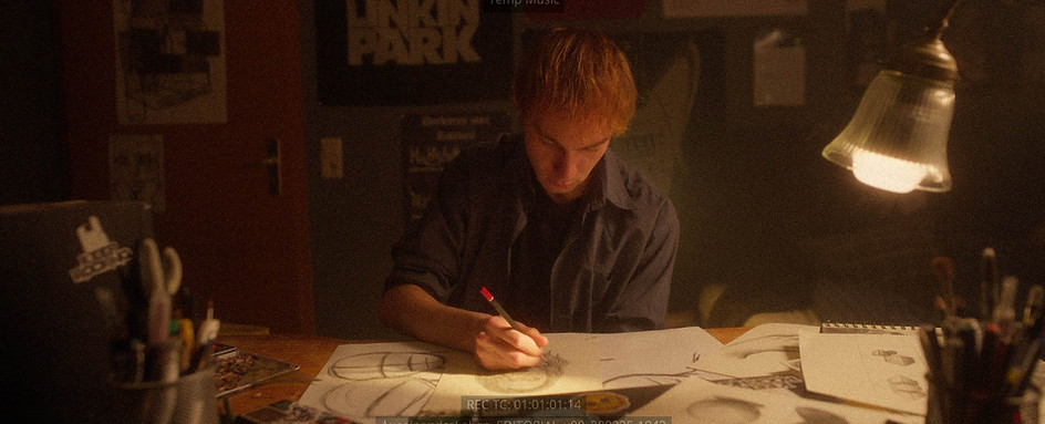 Film Still aus "Auseinader Leben"- Marvin übt Zeichnen an seinem Schreibtisch.