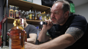 Fiscal avaliando garrafa de bebida