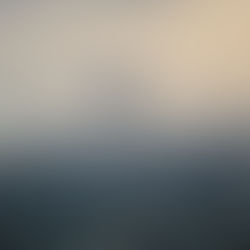 Prédios destruídos ou em condições precárias, com fumaça derivada de explosão no horizonte