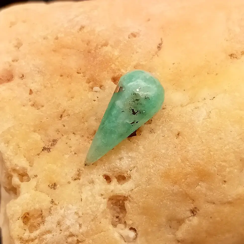 Miniatura: Inclusiones, zonas verdosas y blanquecinas en cabujón de esmeralda colombiana.
