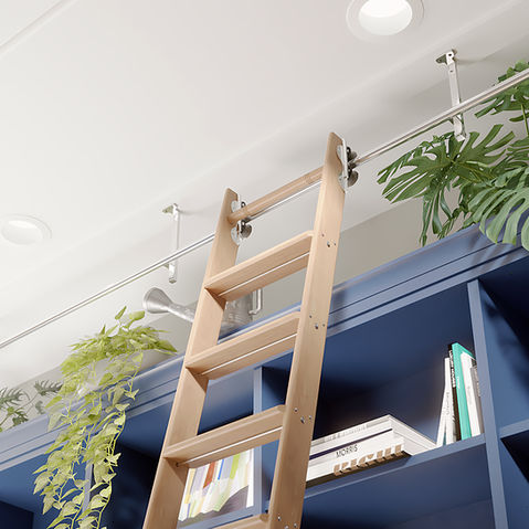 A view of a Quiet Glide rolling ladder as seen from below, as if one was climbing the ladder. From this vantage point we can see the extra details, like the metal rung supports that fit snug under each of the ladder treads. We can also see the solid metal rail from which the sliding ladder is hung; in this case attached to the ceiling and finished in polished aluminum, the double rollers attached to the top of the ladder fitting securely around the rail, no doubt offering a smooth and silent rolling experience.