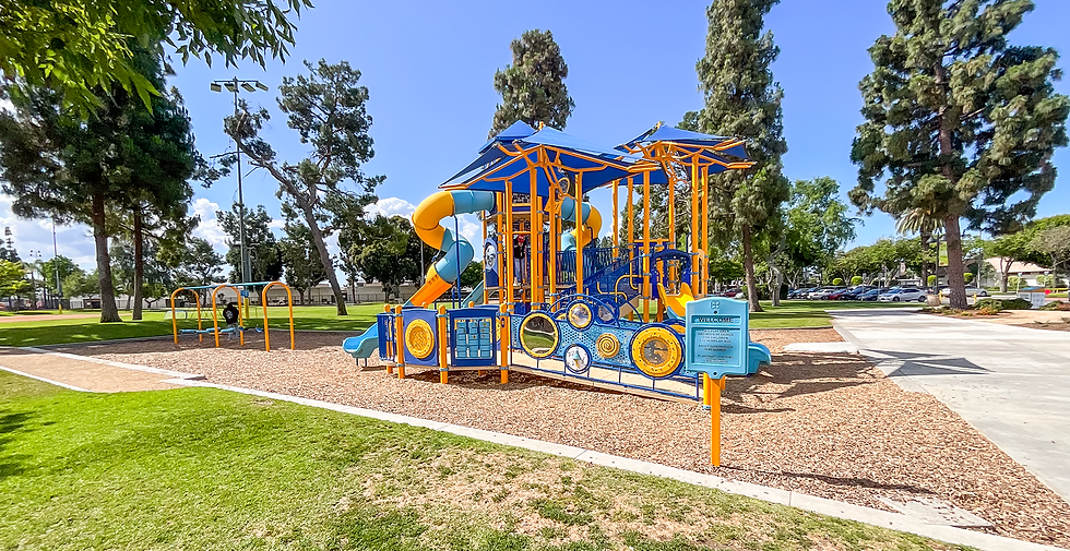 Compliant California public playground with safety surfacing and modern equipment.
