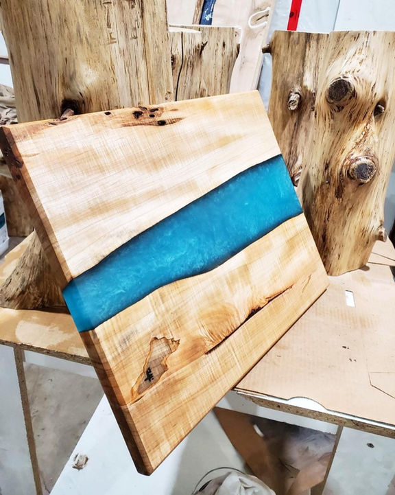 This is a picture of a natural edge slab of wood with a bright blue streak through its centre region