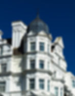 Cinematic perspective of white Victorian architecture.