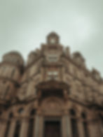 Low-angle photograph capturing the classical architectural facade and intricate stonework of a heritage building.