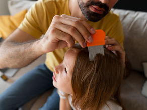 a man removing head lice from a childs hair