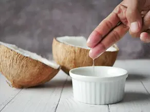 a open coconut and bowl coconut oil