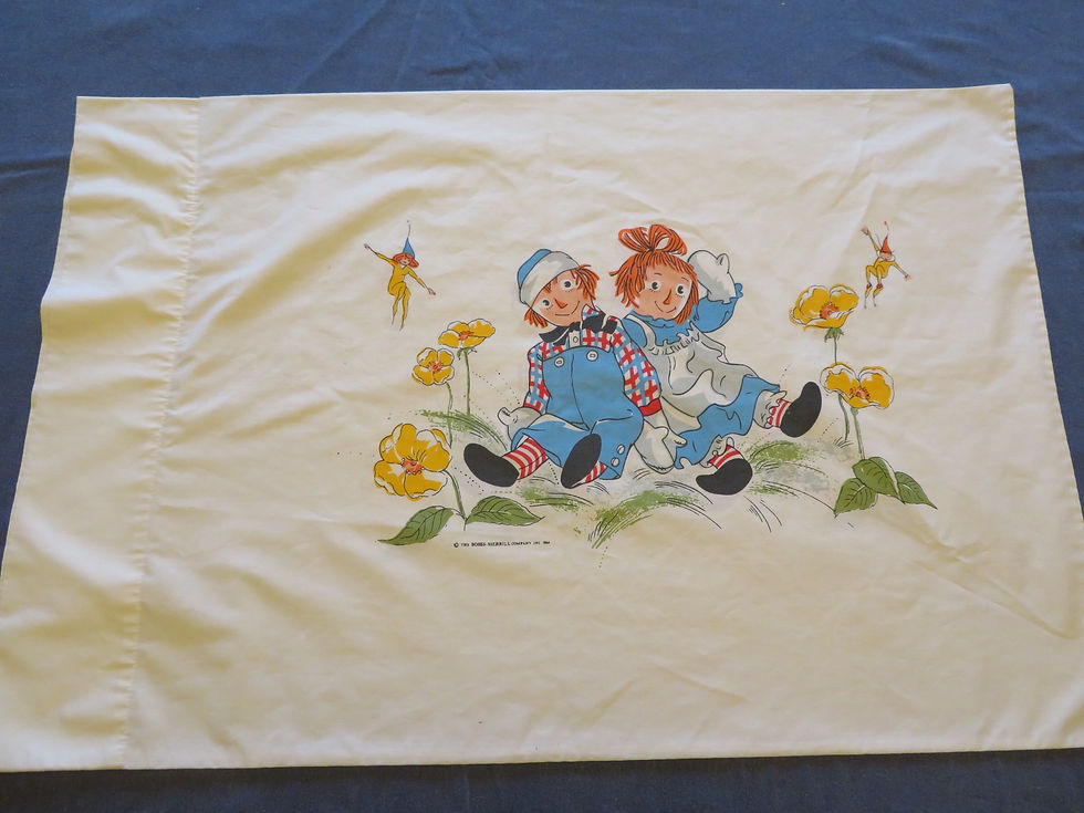 Thumbnail: Raggedy Ann & Andy sitting in a bed of yellow flowers