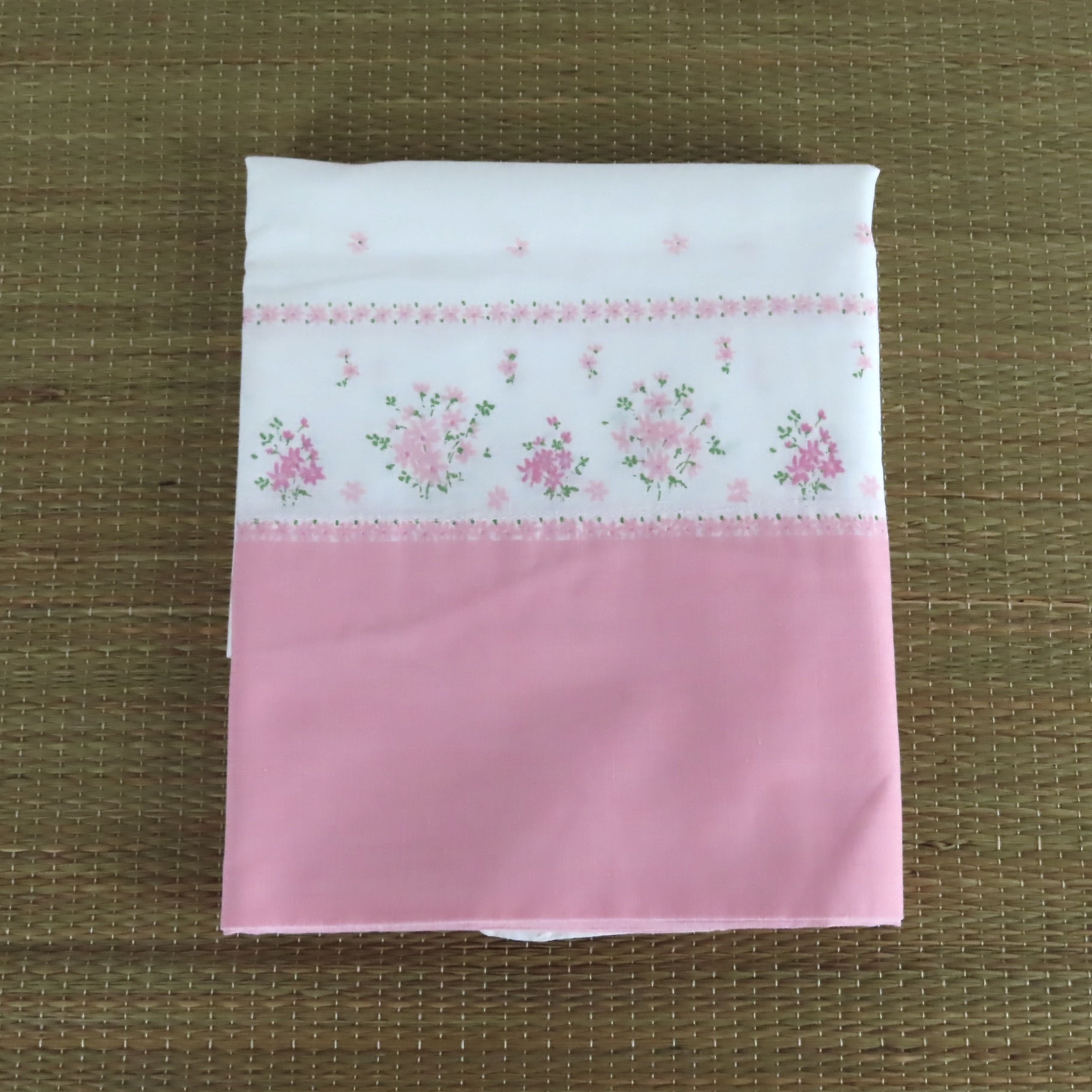 Vintage border print pillowcase is white with small flowers and a solid pink end