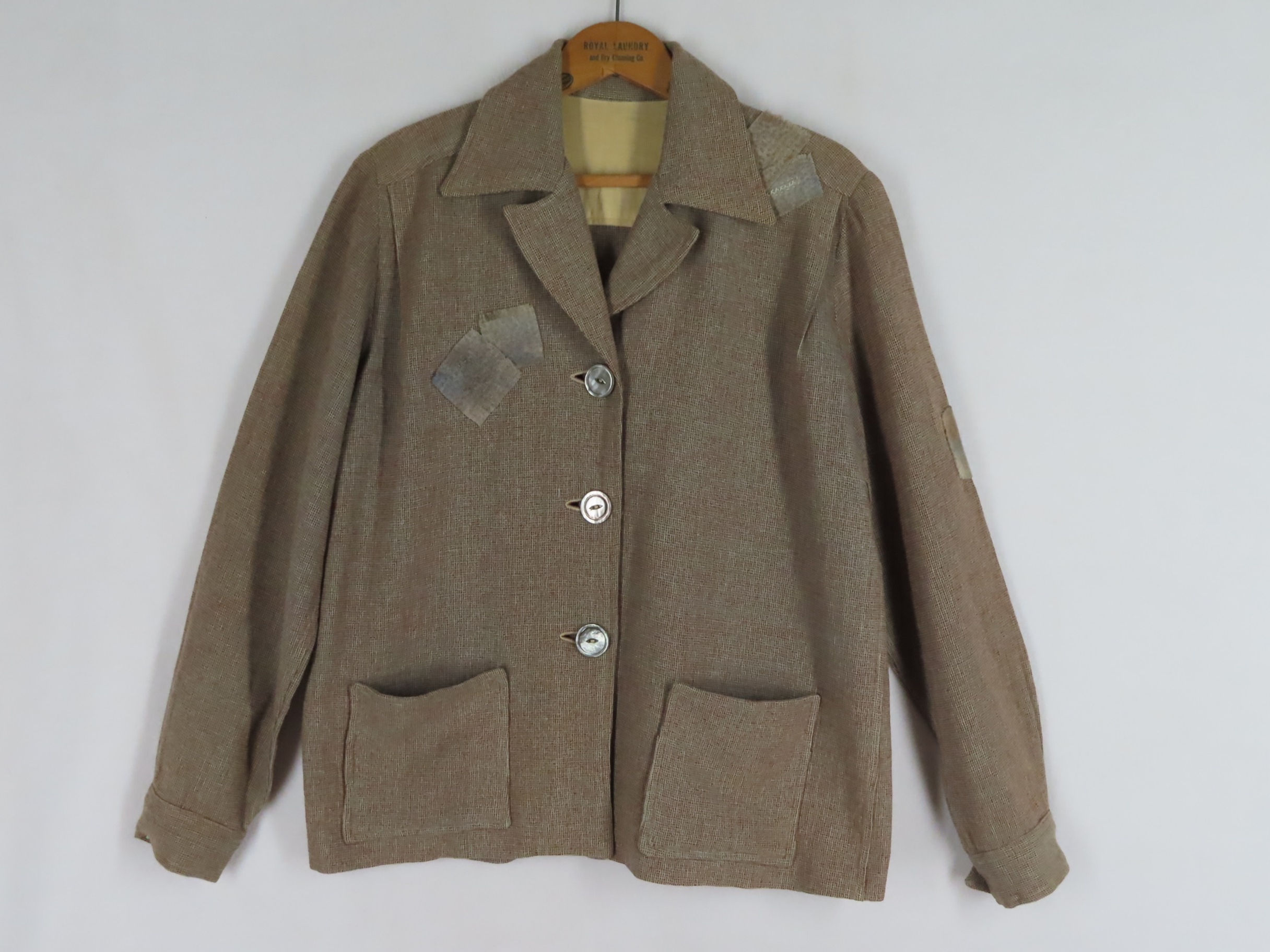 Vintage brown wool jacket that's visibly mended with patches