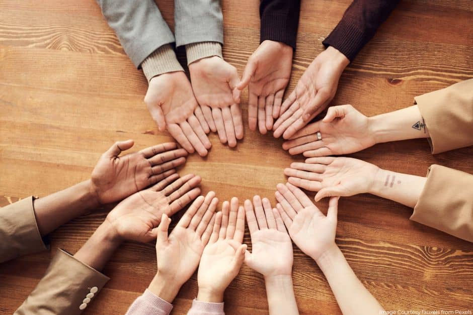 Diverse hands on a wooden table