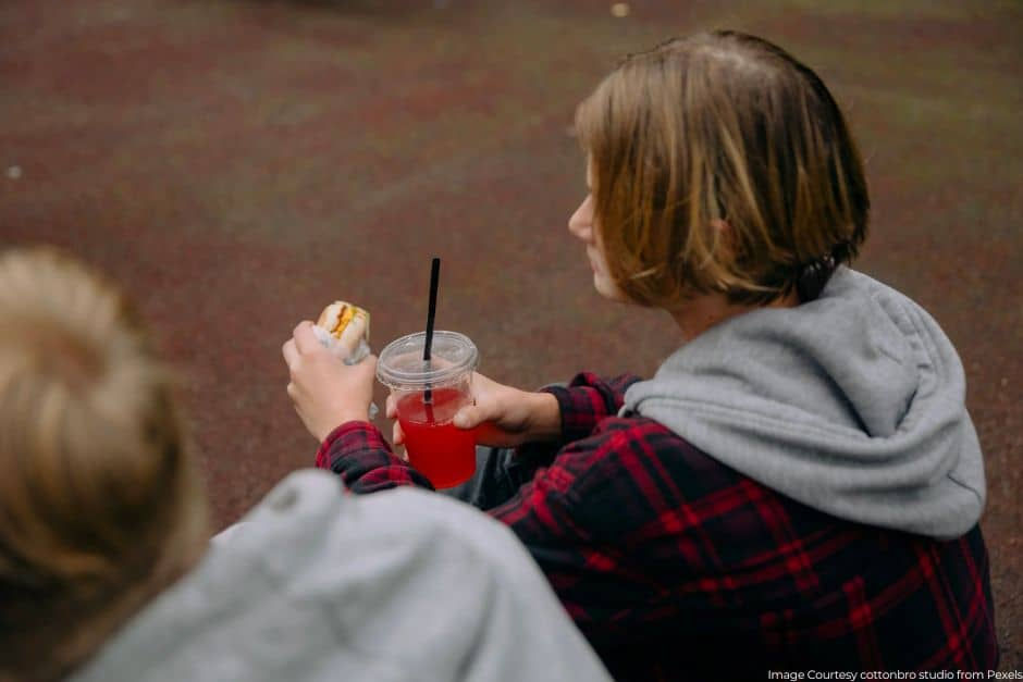 woman holding a burger and soda