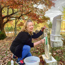 Woman cleaning a headstone at Island Ford Baptist Church