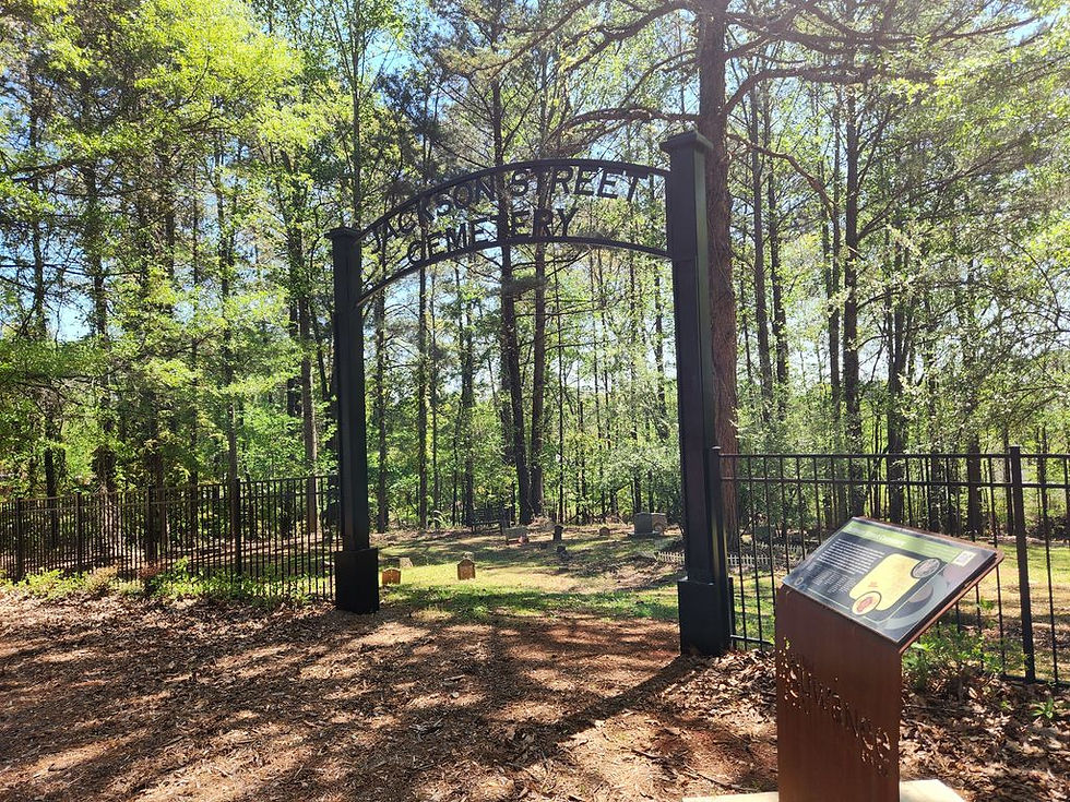 Iron entrance gate and historical information sign at Jackson Street Cemetery in Suwanee, Georgia.