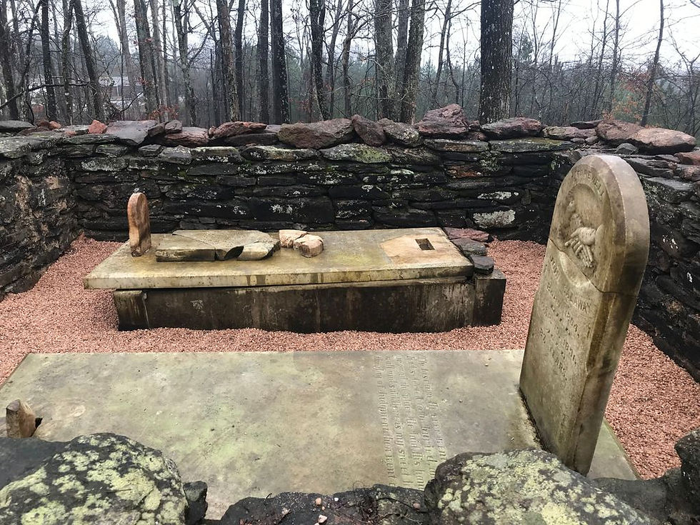 Preserved stone gravesite with headstone within a walled enclosure