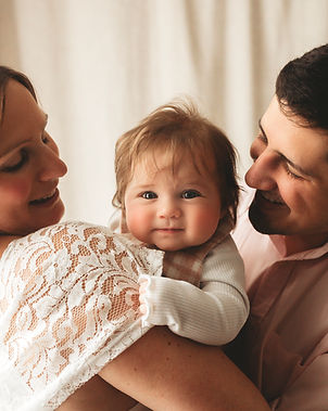 baby being helf by her parents in a family photoshoot