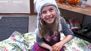 Five year old smiling while carving pumpkins