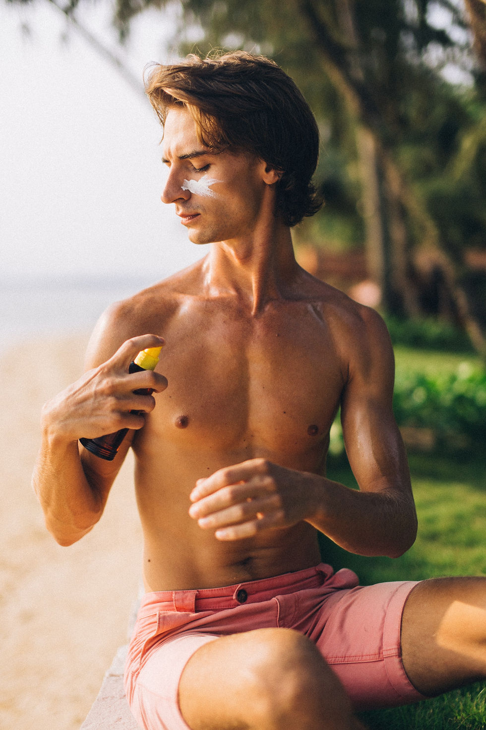 A boy wearing sunscreen, as he is aware of sun damage, photoaging and melanoma, and how it is important to stay protected from sun rays.