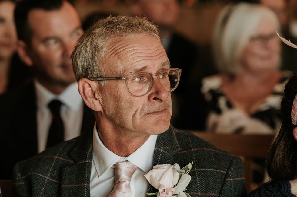 Father of the bride looking at his daughter as she is at the top of the aisle