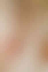 Bride receiving help closing the back of her wedding dress from the mother of the bride