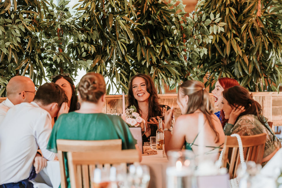 Guests laughing and interacting after speeches at converted barn wedding venue