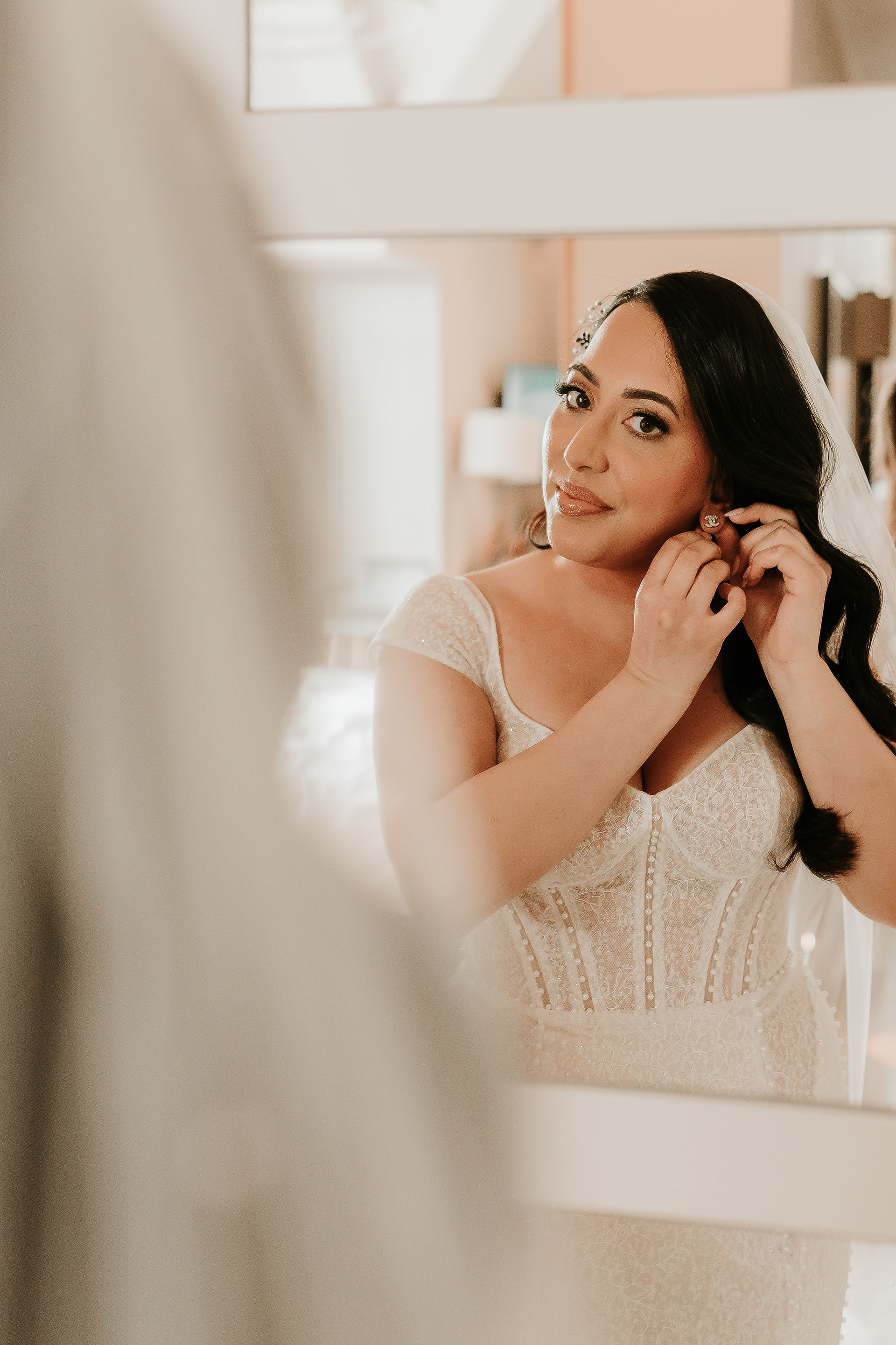 bride getting ready putting on her earrings before the ceremony at sandburn hall york