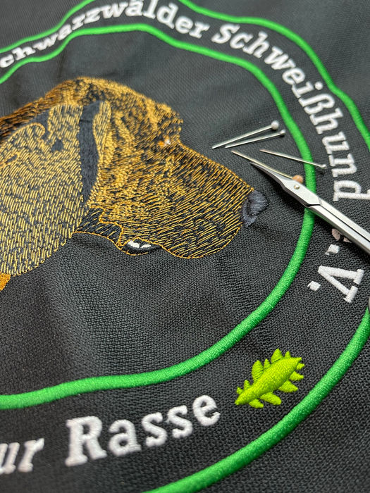 Ein mehrfarbiger Stick eines Logos auf Arbeitskleidung