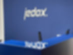 Fräsbuchstaben aus weißem Aluminium-Verbund mit dem Logo „jedox“ an einer dunkelblauen Wand im Empfangsbereich