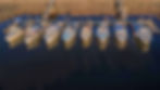 nine fishing boats side by side against a long dock.