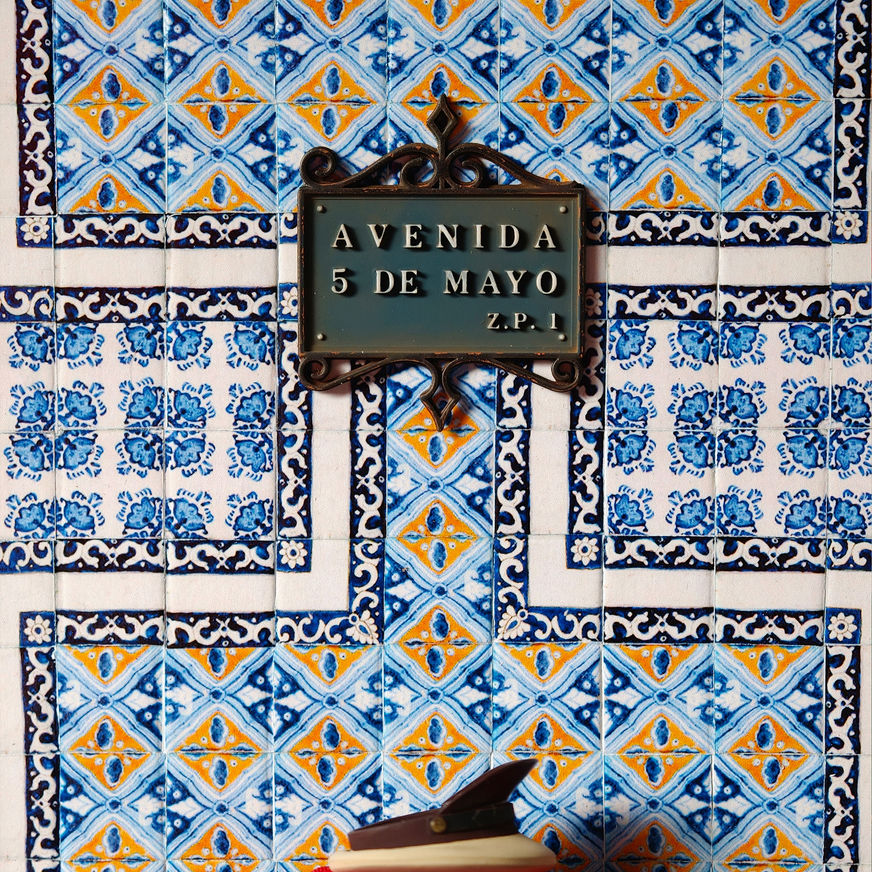 Detalle del letrero de calle miniatura de la Avenida 5 de Mayo montado sobre la fachada de la Casa de los Azulejos