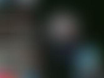 Bright cityscape at night with colorful neon signs and towering advertisements in Japanese. Traffic and buildings create a lively urban scene.