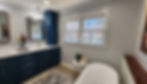 Wide angle view of the spacious bathroom with a modern vanity and custom blue cabinets