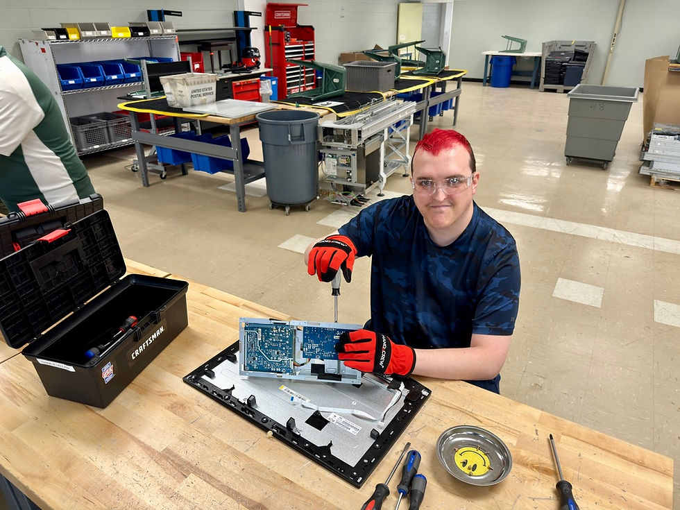 Young man disassembling e-waste at a workbench