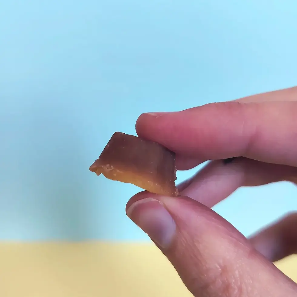 Miniature : Bonbon gélifié Tart Gummy Sakuragi Ryouhinn saveur caramel œuf tenu entre les doigts, texture intérieure fondante visible