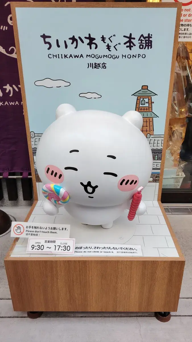 Mascotte géante Chiikawa devant une boutique thématique au Japon