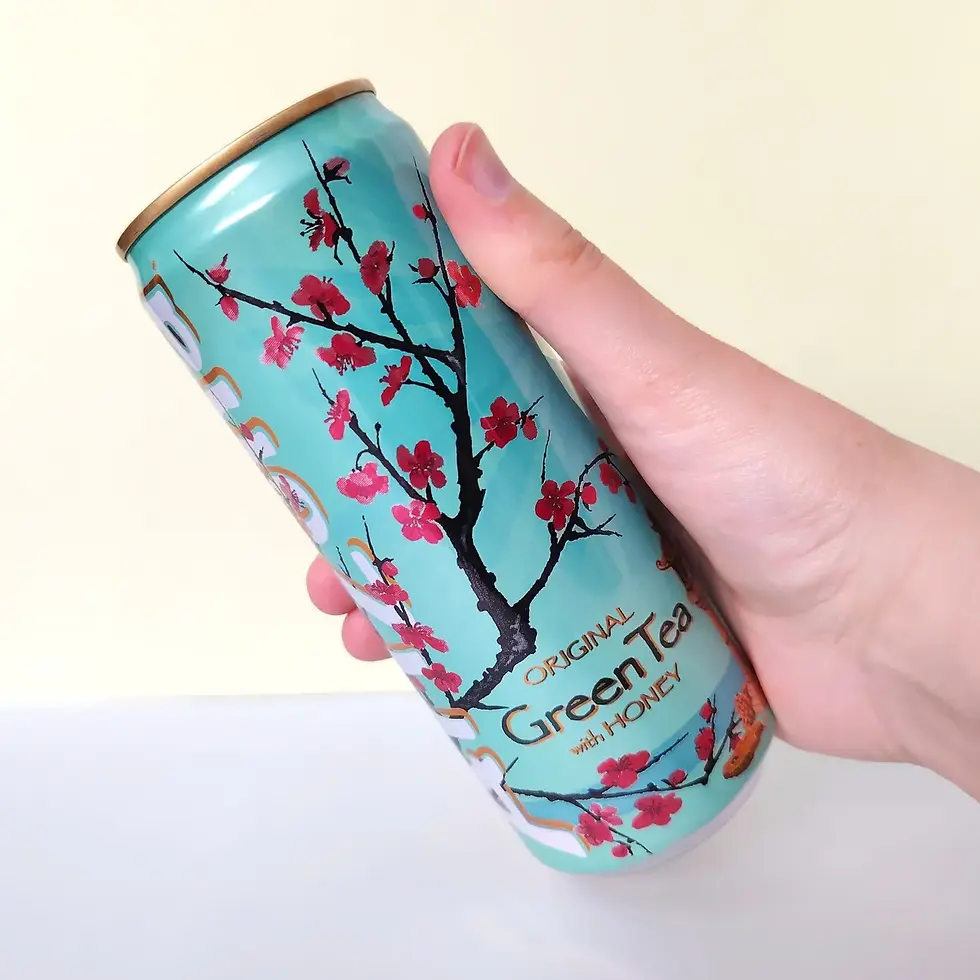 Canette Arizona Thé Vert au Miel 330ml tenue en main, fleurs de cerisier