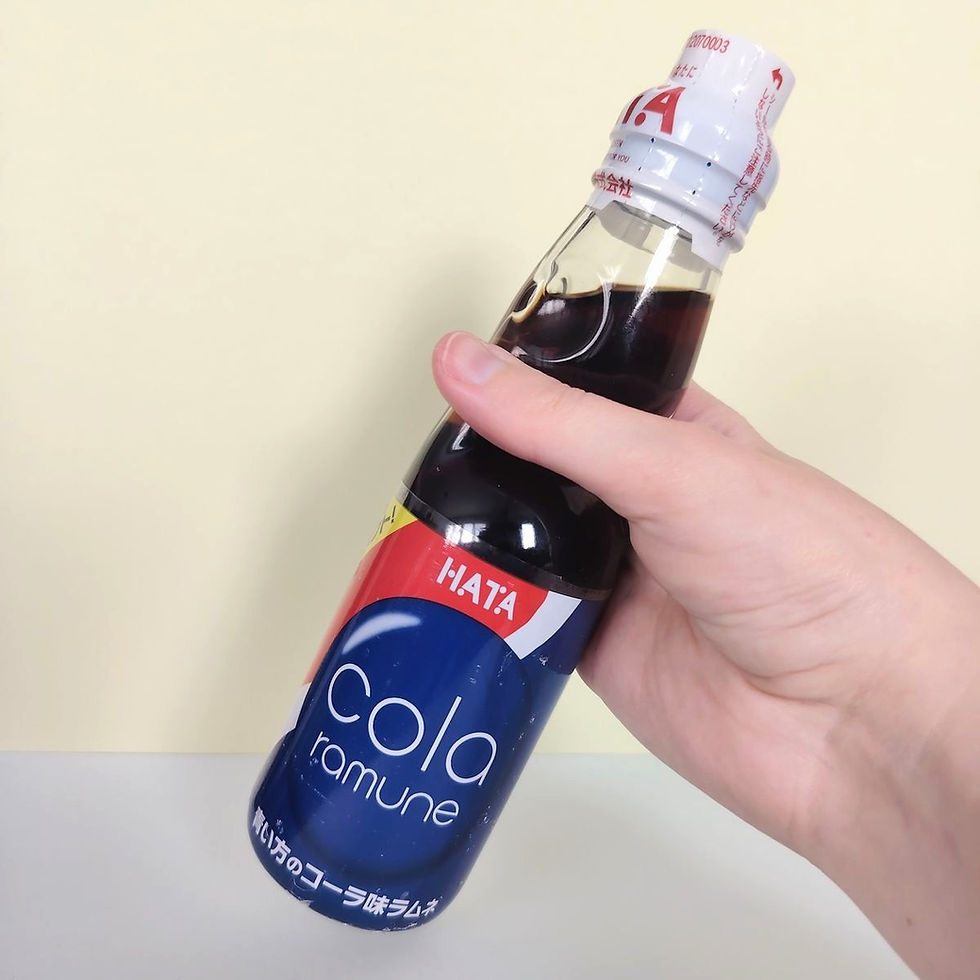 Main tenant une bouteille de Ramune Cola Hata Kosen