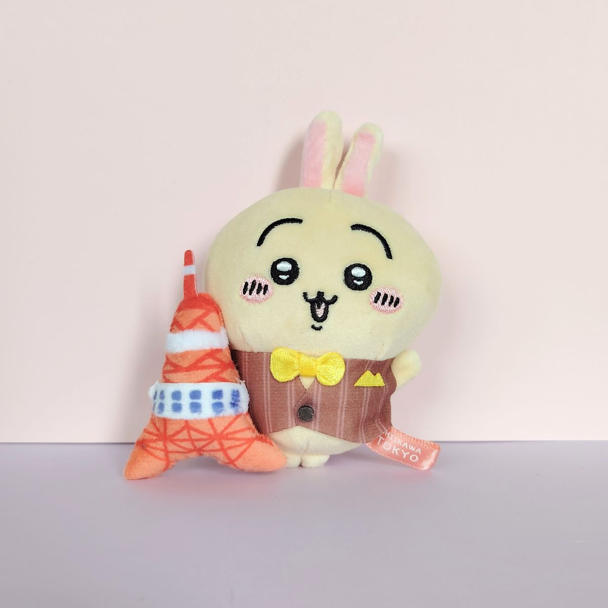 Peluche Usagi Chiikawa Tokyo Tower avec gilet marron et nœud papillon jaune